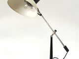 une photo d'une lampe de bureau en noir et blanc posée sur une surface blanche