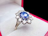 a blue sapphire and diamond ring in a white box