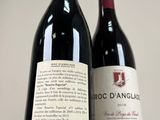 two bottles of red wine sitting next to each other on a table