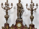 a statue of a man standing next to a clock on a table