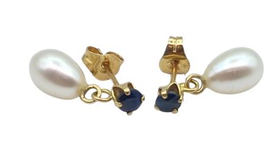 une photo d'une paire de boucles d'oreilles en perles et saphirs