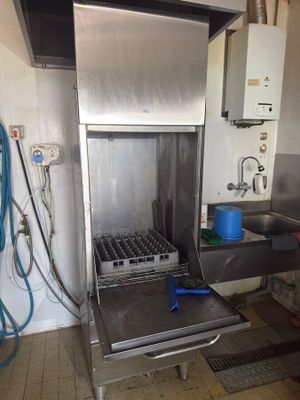 a large stainless steel oven in a kitchen with a blue bucket on the counter