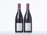 two bottles of red wine sitting on top of a table