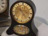 two clocks that are sitting on a white table