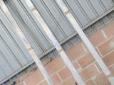 une borne d'incendie rouge posée devant un mur de briques