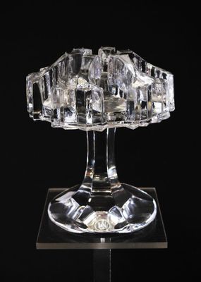 une image représentant une sculpture en verre transparent posée sur une surface noire