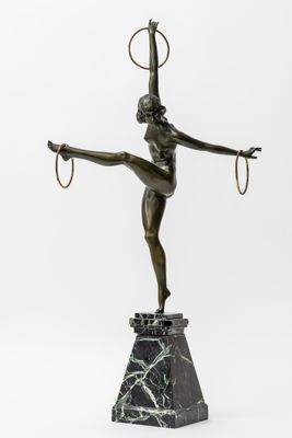 une statue en bronze représentant une femme portant un cerceau sur la tête