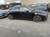 a black car parked in a parking lot next to other cars