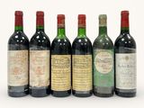 six bouteilles de vin sont alignées sur une surface blanche