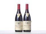 two bottles of red wine sitting next to each other on a table