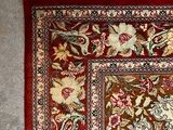 a red and white rug with a floral design on it