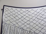 an image of a white and blue blanket on a bed