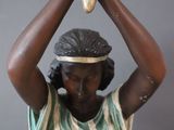 statue of a woman holding a banana over her head