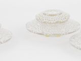 trois bougeoirs en verre transparent posés sur une table blanche