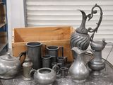 a lot of silver vases and pitchers on a table