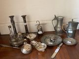 a lot of silver items on the floor next to a wall