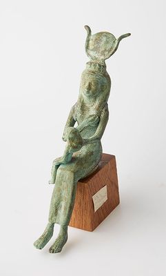 statue d'une femme assise sur un bloc de bois, sur fond blanc