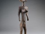 une image représentant une statue en bois d'une femme avec un oiseau sur la tête