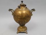 an antique brass urn with two handles and a bird on top