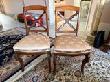 pair of antique dining chairs with upholstered seat cushions
