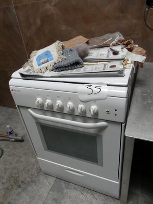 une cuisinière sur laquelle sont posés tout un tas d'objets
