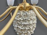 a gold chandelier with white flowers hanging from the ceiling