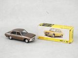 La petite voiture se trouve à côté de la boîte, sur la table.
