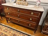 a marble top chest of drawers with a clock on top