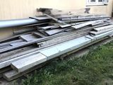 a pile of wood on the ground outside of a house