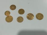 a close up of some gold coins on a white surface