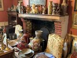 un salon avec une cheminée et de nombreux vases