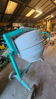 une bétonnière rangée dans un garage avec d'autres outils