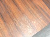 someone is cutting a piece of wood with a knife on a cutting board