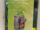 a bag of potatoes sitting on a table with a plant in it