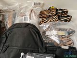 a black backpack that is packed with items for a trip