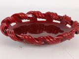 une image représentant un bol rouge posé sur une surface blanche
