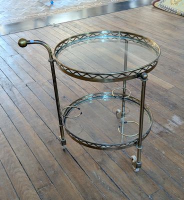 une table en verre à roulettes posée sur un parquet