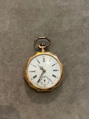 une montre de poche ancienne avec des chiffres romains sur le cadran