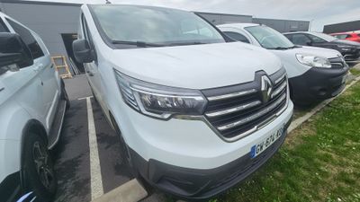 La camionnette blanche est garée à côté d'autres voitures sur le parking.