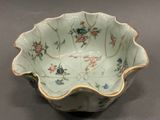 a white bowl with flowers on it on a table