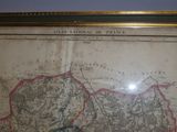an old map of france in a gold frame on a blue wall
