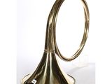 a brass plated trumpet with a curved horn on a stand