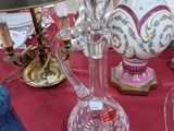 de nombreux vases en verre posés sur une table sur laquelle se trouve une lampe