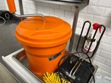a large orange bucket sitting on top of a sink
