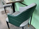 a green and white chair and a table in a restaurant