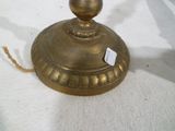 une petite lampe en laiton posée sur une table blanche