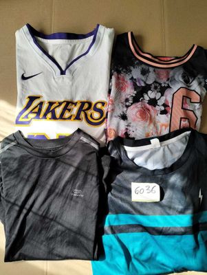 three t - shirts are sitting on a bed with a tag on it