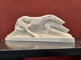 a white sculpture of a dog and a cat on a table