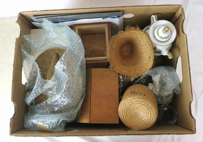 une boîte en carton remplie d'objets, notamment des chapeaux et d'autres articles