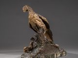 bronze sculpture of a hawk perched on a tree stump